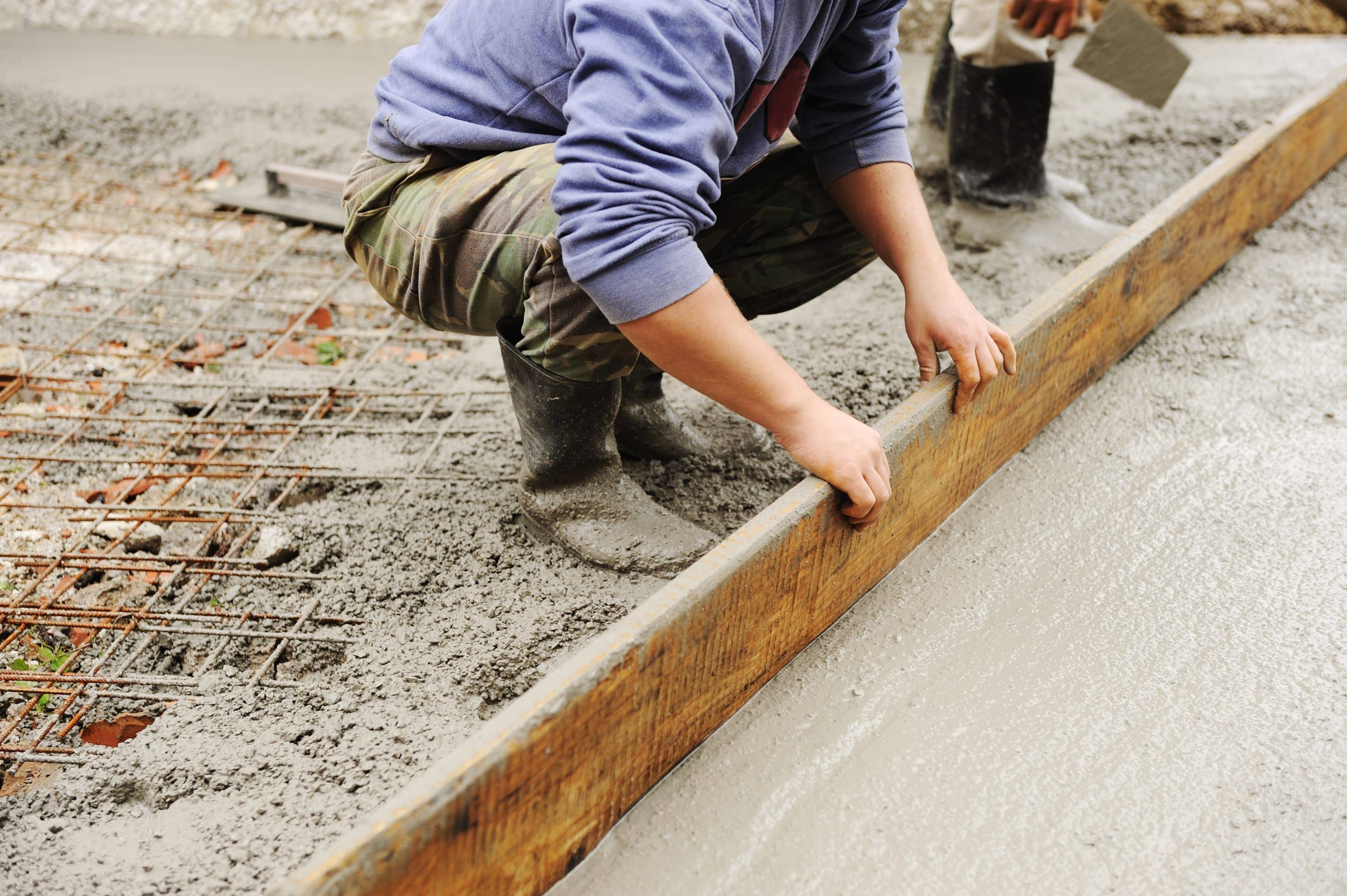 worker-smoothing-fresh-concrete-on-construction-si-2026-04-14-01-11-03-utc Pose du film polyane avant le coulage d'une dalle béton